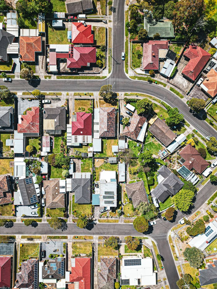 Drone shot of a colorful Melbourne suburb with vibrant rooftops and streets on a sunny day.