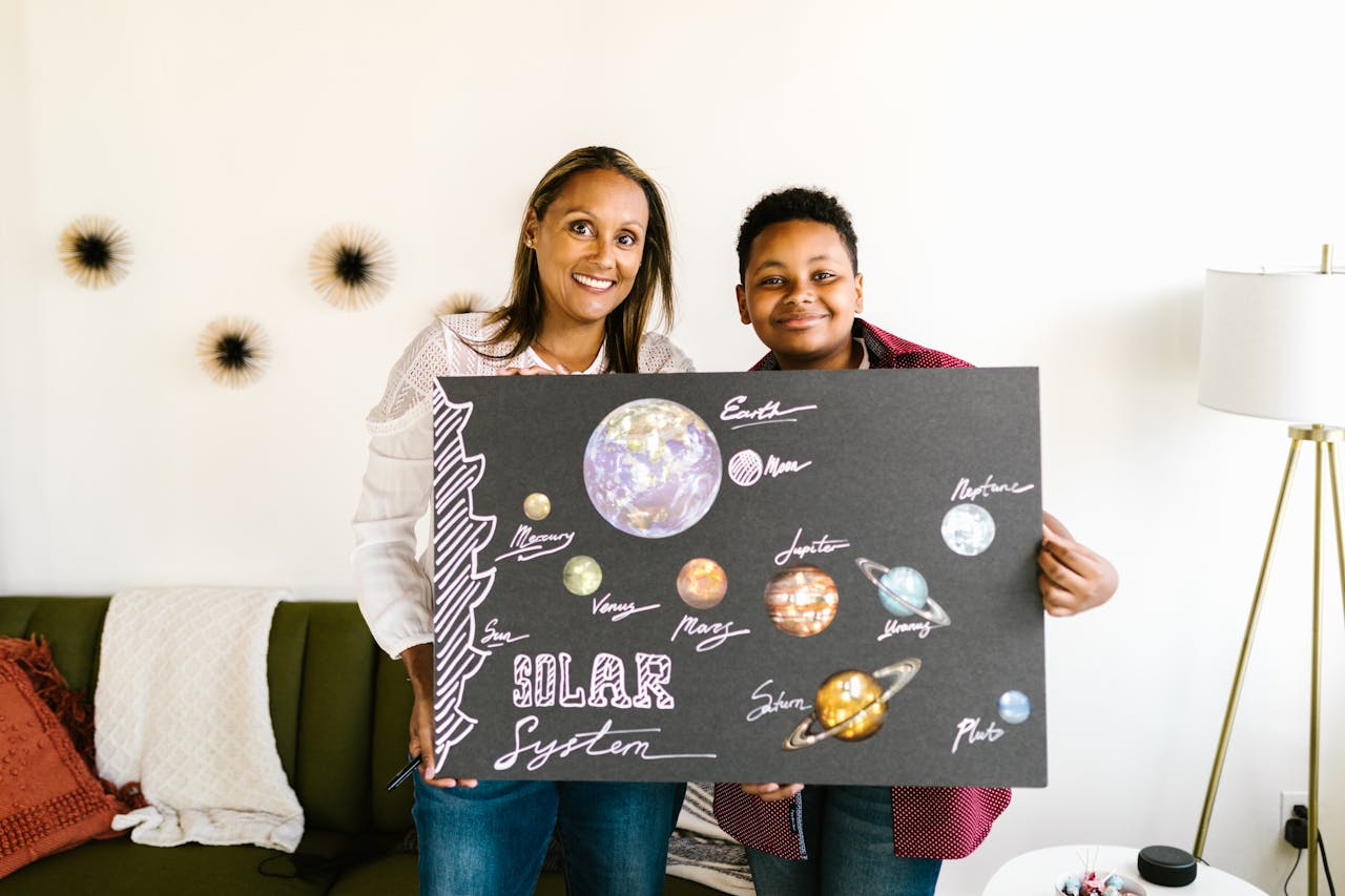 A mother and son proudly display their handmade solar system project.